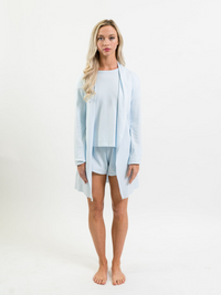 model standing wearing light blue cardigan over pajamas