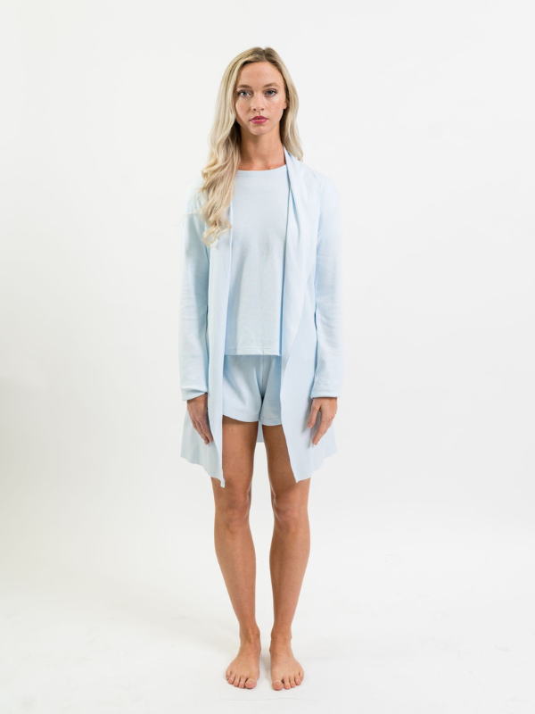 model standing wearing light blue cardigan over pajamas