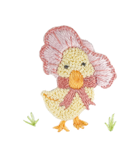 A white converter gown for babies with a hand-embroidered design of a baby duck wearing a bonnet.