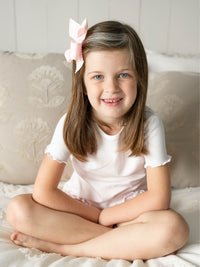 Toddler girl wearing Milly Marie Pima ruffle lounge set in pink mini stripe, featuring lettuce hem short sleeve top and ruffle hem shorts. Made from soft Peruvian Pima cotton.