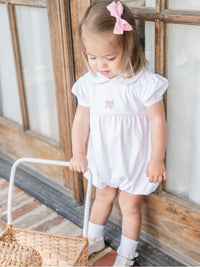 toddler girl wearing white Pima cotton baby bubble with pink bow