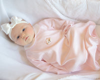 Newborn baby wearing light pink day gown with hand embroidered puppy