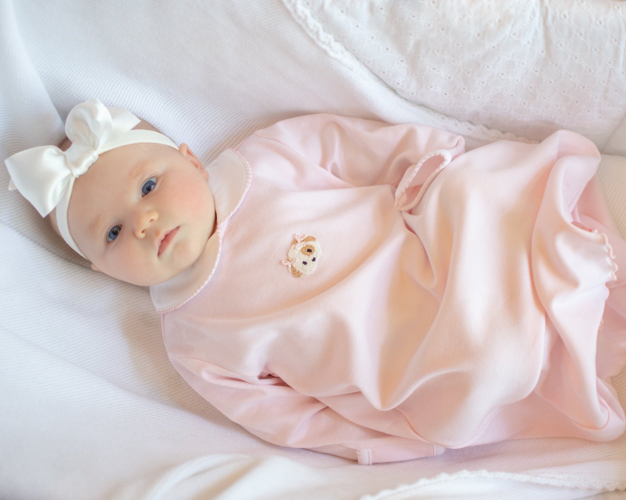 Newborn baby wearing light pink day gown with hand embroidered puppy