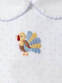 Embroidered turkey design on a white fabric with blue polka dots