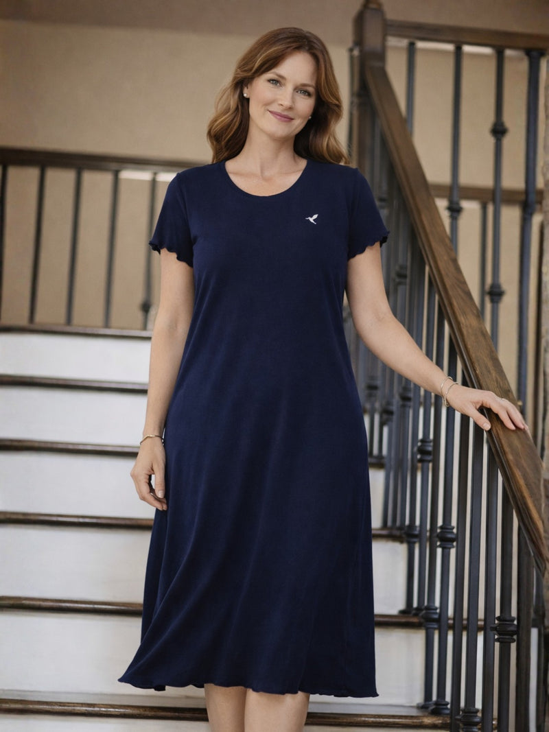 Woman wearing a navy blue midi nightgown standing on a staircase
