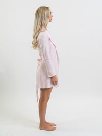 Woman wearing a light pink Pima cotton robe on a white background