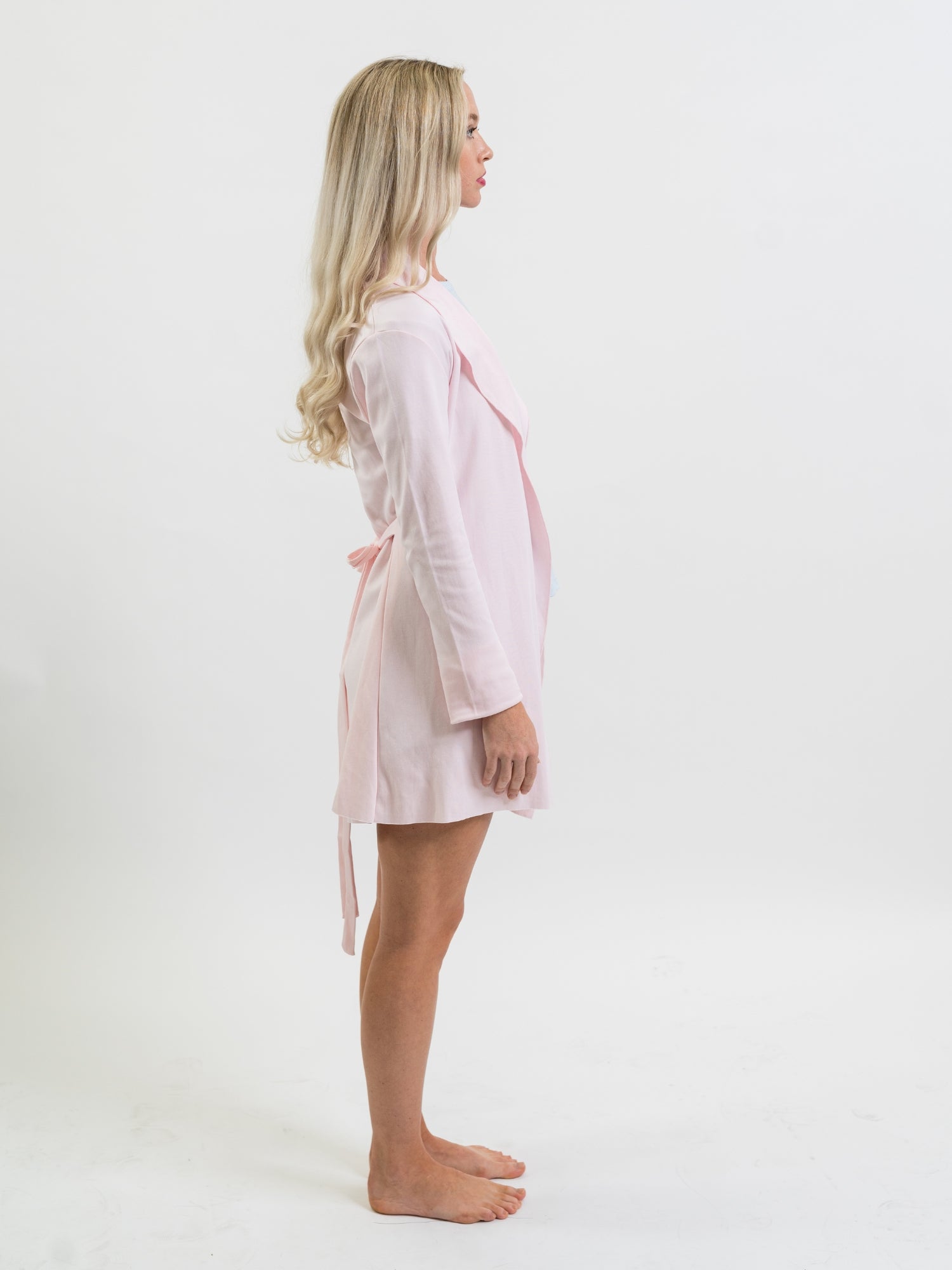Woman wearing a light pink Pima cotton robe on a white background