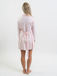 Woman wearing a light pink Pima cotton robe on a white background - showing back of garment